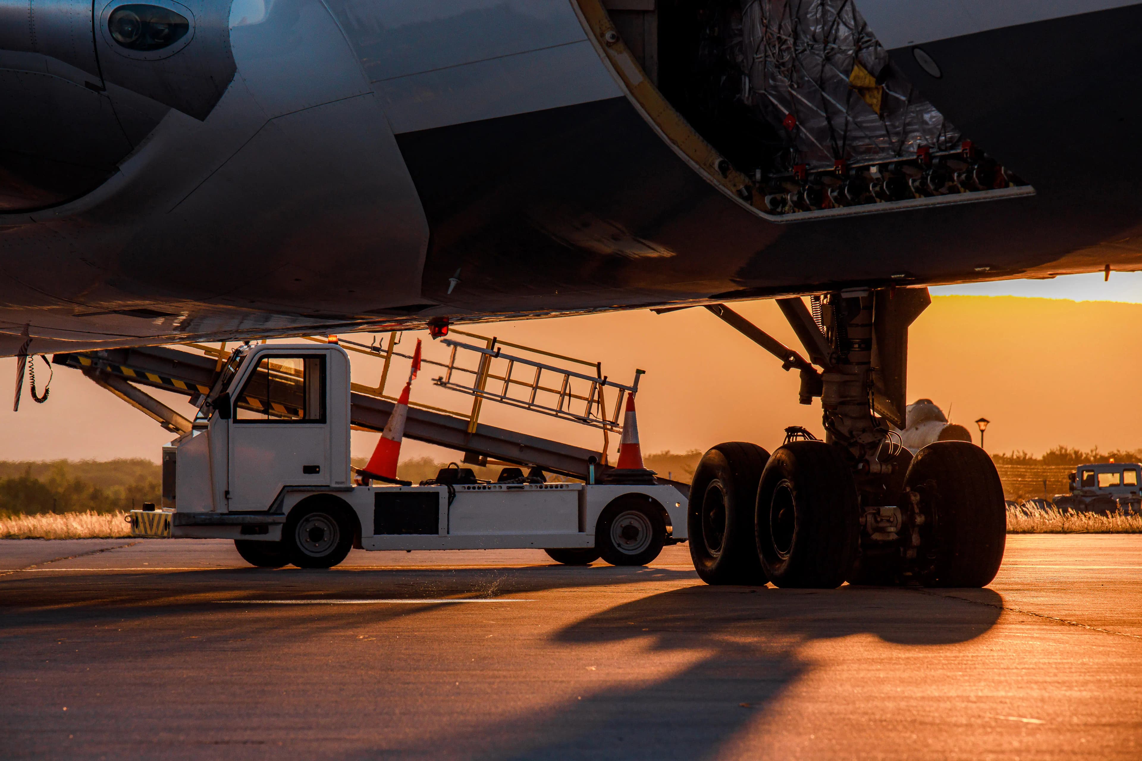 Aircraft being serviced under sunset